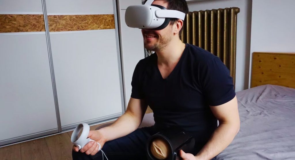 A man holding a Fleshlight in one hand, wearing a VR headset