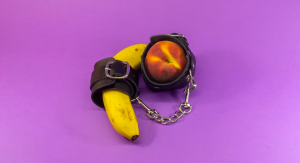 A banana and a peach inside handcuffs