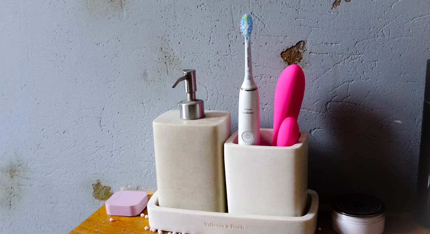 A vibrator inside a toothbrush holder stand next to a toothbrush