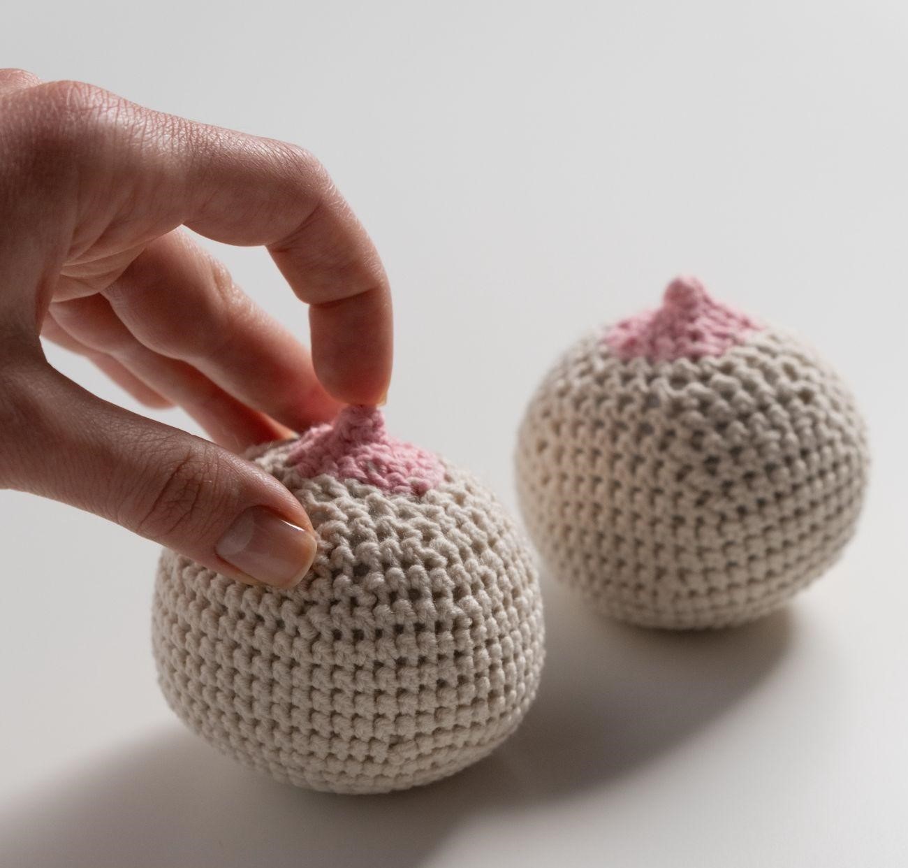 Person touching nipples made from knitted balls