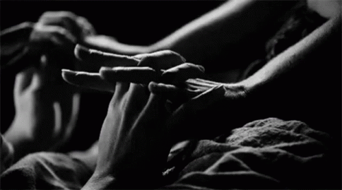 Two people holding and linking their hands together